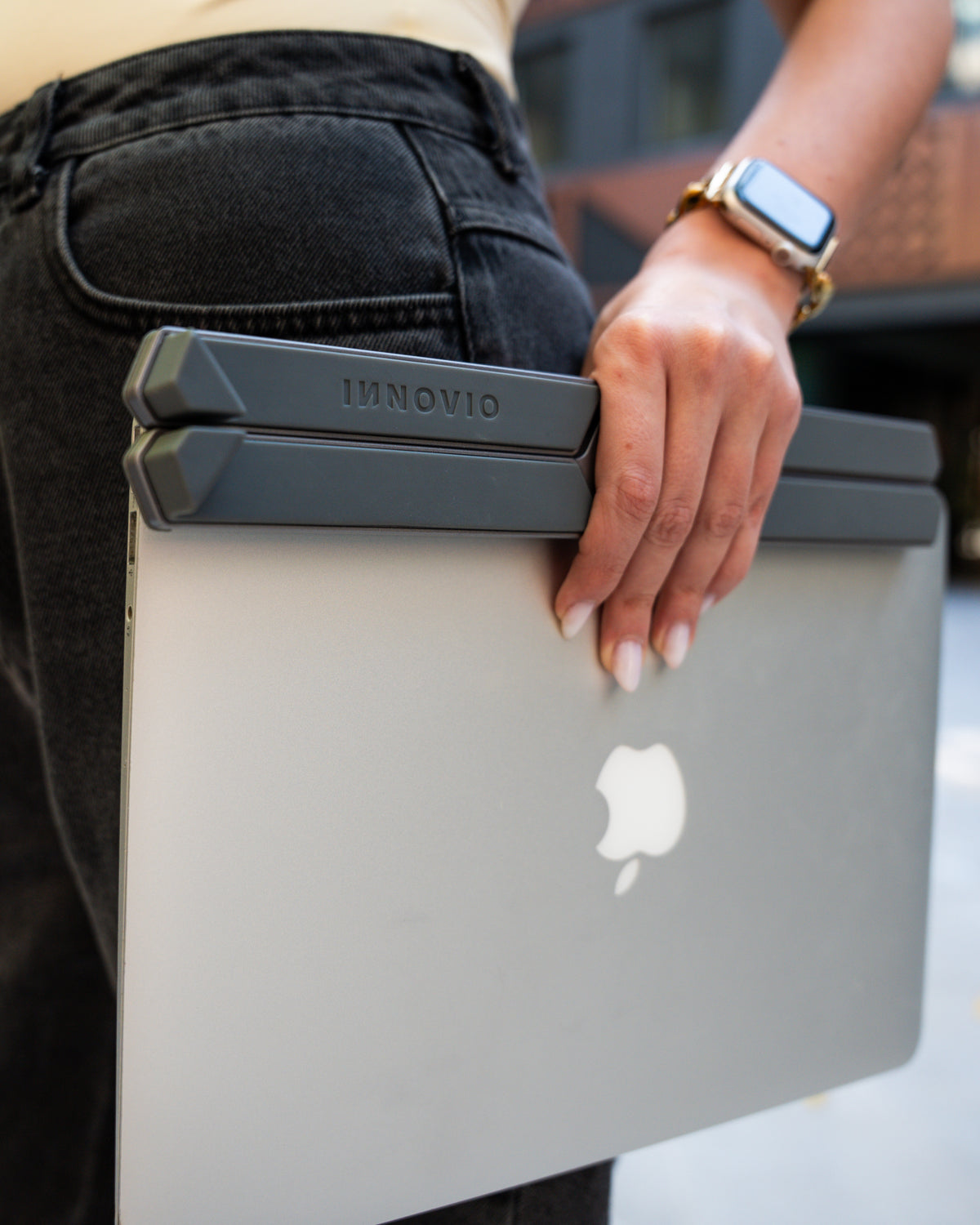 Woman carrying her laptop and the folded Dual Pro top in the city