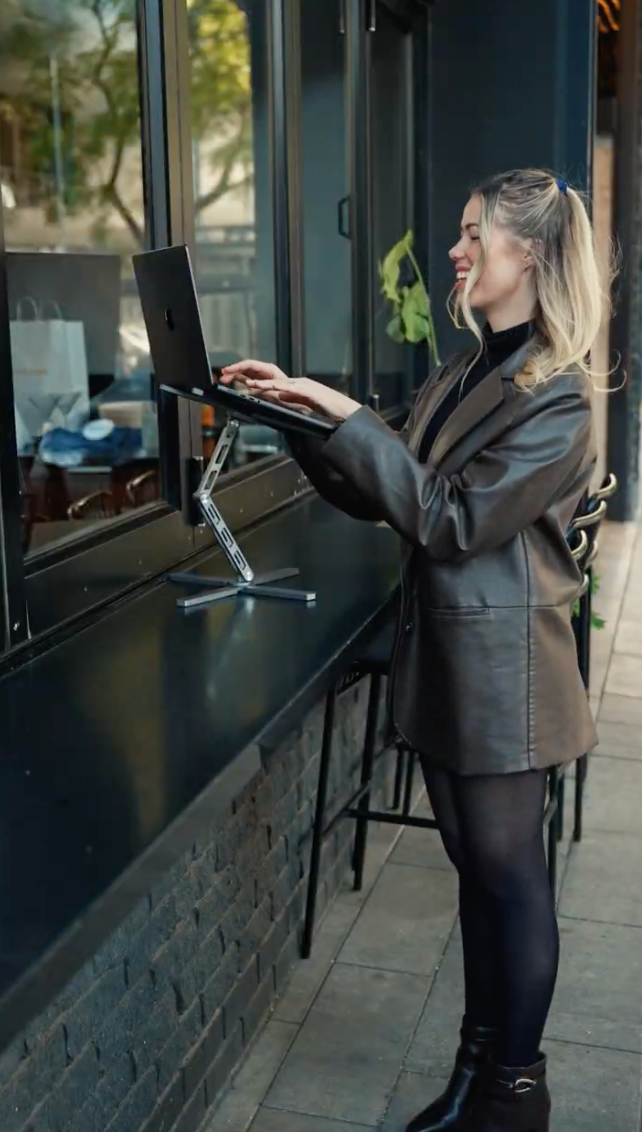 Typing standing up at a raised laptop