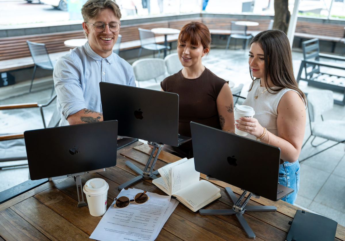 Woman with a coffee next to her laptop on INNOVIO Dual Pro